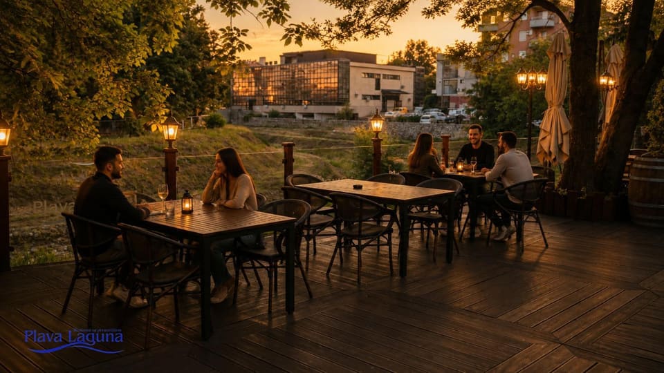 Terasa u suton, upaljeni fenjeri na stolovima i ulične lampe